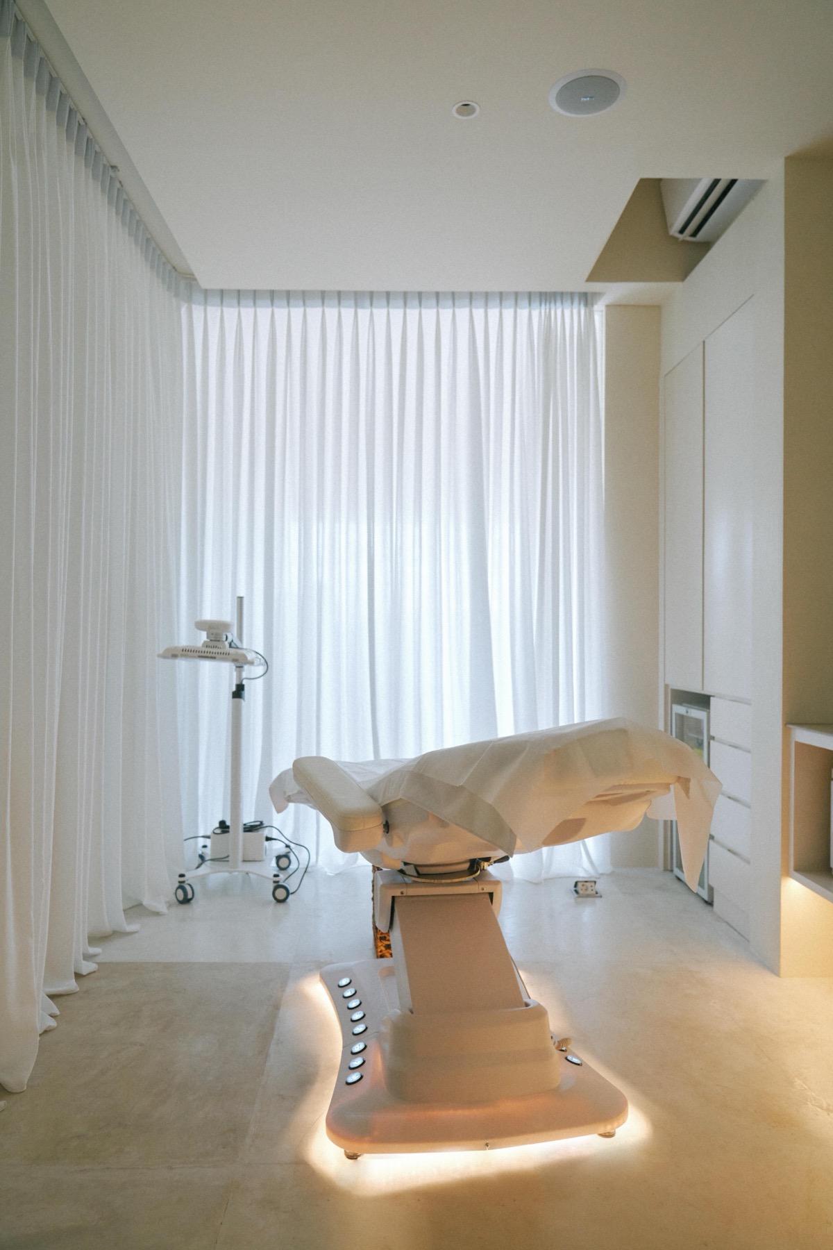 Treatment room at Aesthé SkinLab: a bed beneath sheer white curtains